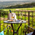 table overlooking a vineyard and two glasses of wine